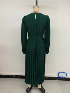 Detail view of the back collar button and vertical pleats on a long dark green dress