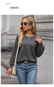 Detail shot of dark grey textured sweater with geometric patterns and ribbed cuffs