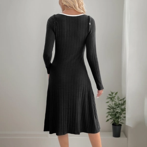 Elegante abito in maglia nera a trapezio con bordo bianco a contrasto e bottoni decorativi