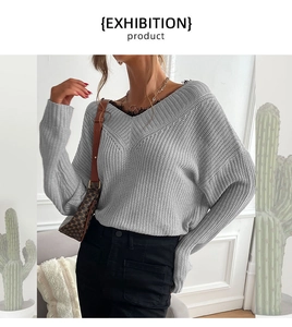 Detail of grey V-neck knit sweater featuring delicate black lace trim and thick texture