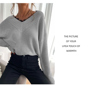 Detailed view of the light grey V-neck knitted sweater with delicate lace stitching details