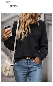 Detail of black long sleeve top showing 3D geometric waffle texture and crew neck
