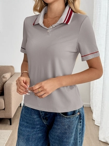 Detail of grey ribbed polo top with red contrast striped collar and knit texture