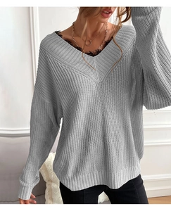 Detail of grey V-neck knit sweater featuring delicate black lace trim at the neckline