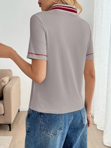 Rear view of grey ribbed polo shirt featuring red contrast stripes and a minimalist look