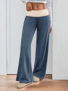 Detail of the high-waisted beige waistband on gray-blue loose-fitting wide-leg trousers