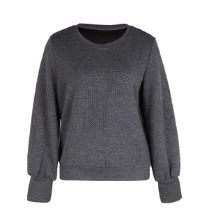 Detail of dark grey textured sweatshirt showing herringbone patterns and ribbed cuffs