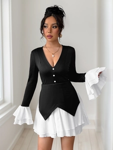 Detailed view of layered white pleated hem and ruffle cuffs on contrast dress