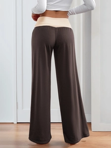 Rear view of brown wide-leg pants featuring a contrasting high-waist band on a model