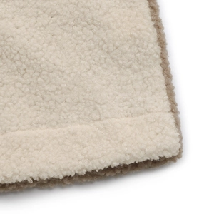 Close-up of dual-tone thick sherpa fleece fabric showing warm texture and neat stitching