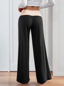 Detailed back view of wide-leg trousers with two-tone waist contrast on female model