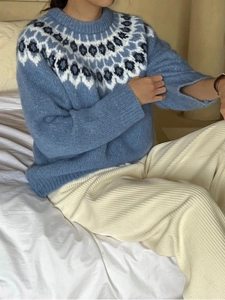 Detail of light blue knit sweater featuring geometric jacquard patterns on the neckline