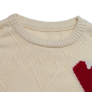 Detailed view of rib-knitted crew neck with red heart jacquard on cream knit sweater