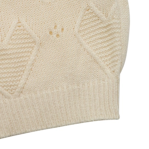 Detail of off-white knitted sweater with hollow diamond jacquard and ribbed cuff texture