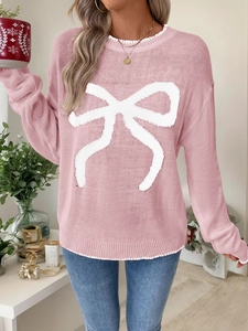 Close-up of pink Christmas knit sweater with large white bow pattern and ribbed cuffs