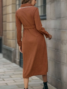 Back view of a caramel corduroy midi dress with long sleeves and elegant waist belt