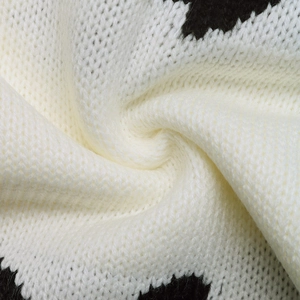 Gros plan sur un tissu en maille douce avec motif vache noir et blanc et texture