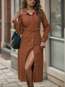 Detail view of brown corduroy shirt dress featuring white lace collar and button-down front