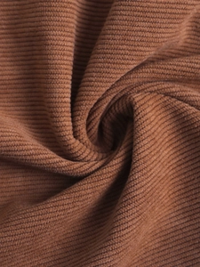 Detailed macro shot of brown ribbed corduroy fabric showing soft texture and high quality