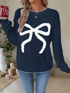 Detail of navy knit sweater with large white bow pattern and contrast stitching