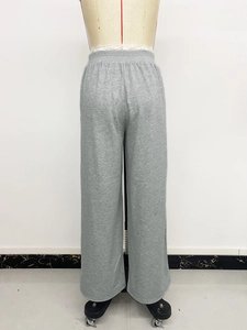 Detail of high-waisted wide-leg trousers with elastic waistband in soft grey knit fabric