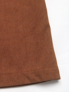 Macro shot of dark brown corduroy fabric showing fine vertical texture and hem stitching
