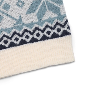 Detailed view of blue snowflake jacquard knit and ribbed hem on Christmas sweater