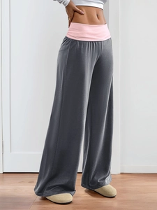 Detail of high-waist yoga pants featuring a charcoal body and pink elastic waistband