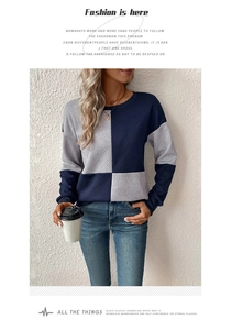 Detail of color-block sweatshirt featuring navy and gray panels with textured diamond knit