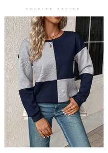 Detail of navy and grey textured patchwork sweater showing 3D geometric knit pattern