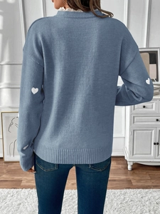 Detail view of haze blue sweater featuring white lace collar and heart patterned sleeves