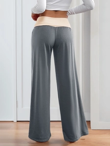 Rear view of brown low-waisted wide-leg trousers featuring a beige waistband detail