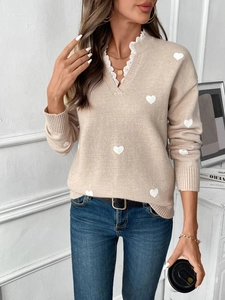 Close-up of heart pattern knit sweater with lace trim V-neck and ribbed cuffs