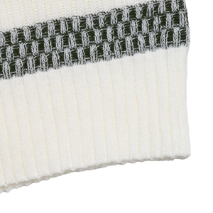 Close-up of white ribbed knit fabric featuring a decorative dark geometric pattern band