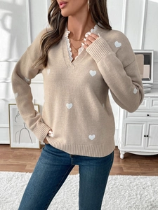 Detail of V-neck sweater showing white lace trim and heart pattern knitted texture