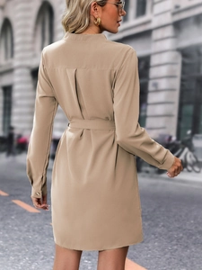 Back view of a khaki long sleeve shirt dress showing inverted pleats and waist belt details