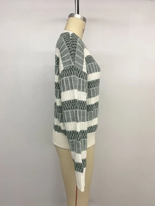 Detail of green and white striped knit sweater with geometric jacquard pattern