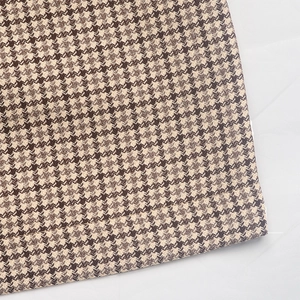 Gros plan détaillé de la texture pied-de-poule marron et des coutures de la veste chic