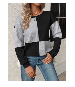 Detail shot of long-sleeve sweater with textured knit fabric and black-grey color block