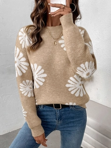 Nahaufnahme von khakifarbenem Strickpullover mit weißen Gänseblümchenmustern und Rippbündchen