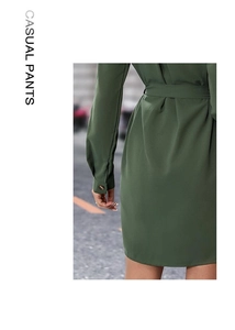 Detail of olive green V-neck dress with textured fabric and buttoned long sleeves