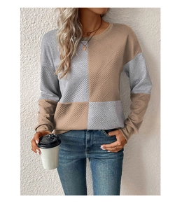 Close-up of textured knit sweatshirt featuring grey and brown color-blocking detail