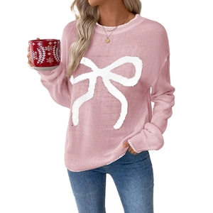 Cozy pink Christmas sweater for women featuring a large white bow and a festive crew neck