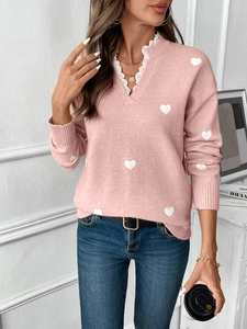 Detail view of the V-neckline with delicate white lace trim on the pink heart sweater