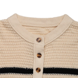 Close-up of beige waffle knit sweater collar with striped pattern and tortoiseshell buttons
