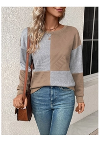 Detail showing the textured knit fabric and geometric color block design of the sweater