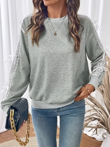 Detail of grey crewneck sweatshirt with lace patchwork sleeves and white decorative bows