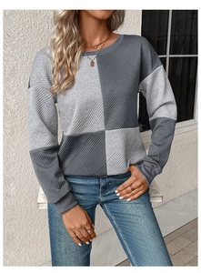 Close-up of long sleeve textured sweatshirt with grey colorblock paneling and crew neck