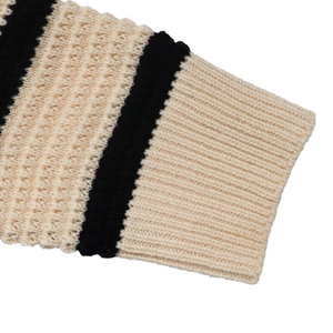 Detailed macro view of the black and beige striped ribbed knit cuff texture