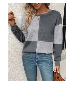 Detail showing the patchwork design and geometric textured fabric of the gray sweatshirt